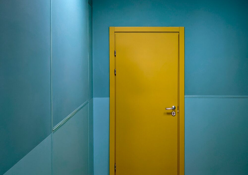 gelbe Tür mit blauen Wänden